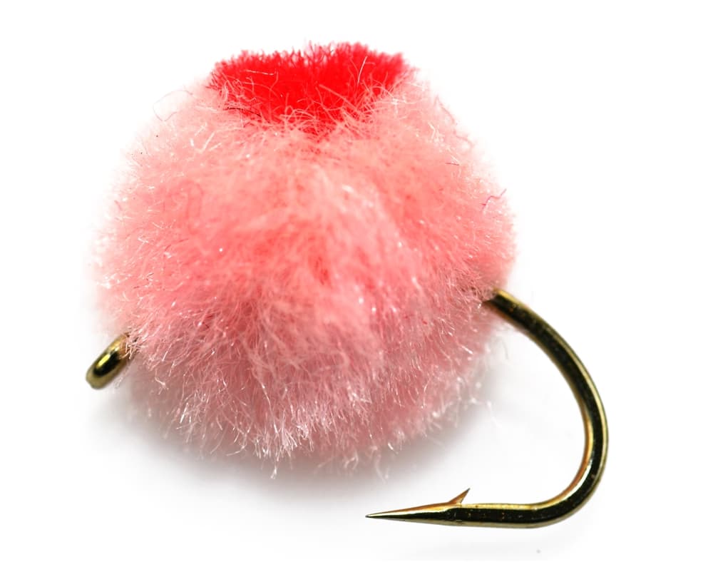 Close photograph of a pink roe egg fly with a red center spot tied directly to a visible hook