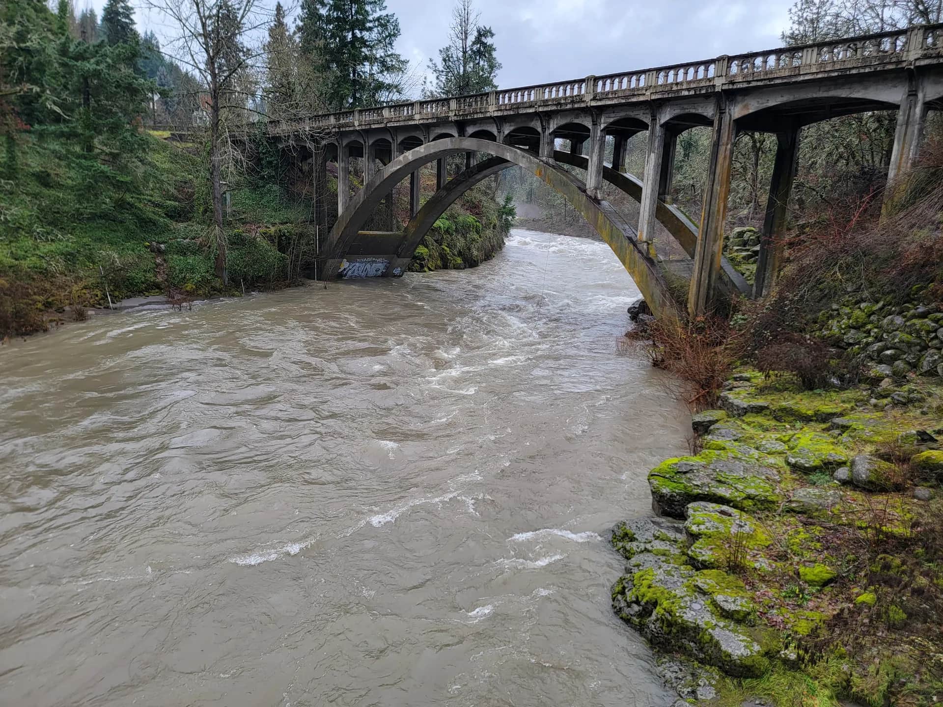 Historical December 2023 high-water view of the Hood River rushing beneath Tucker Bridge near USGS gage 14120000.